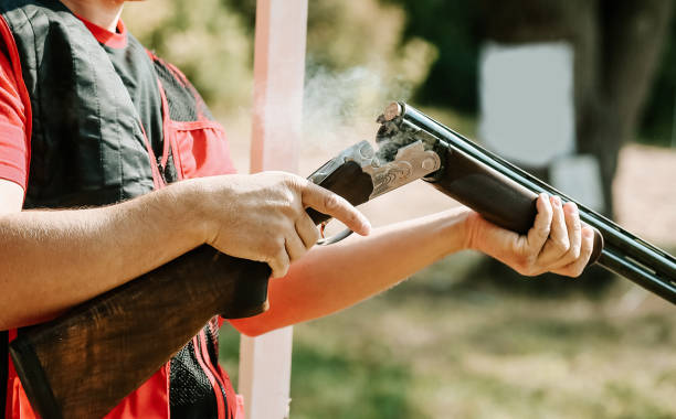 istock man opens the shotgun bolt after one shot with smoke 971089540