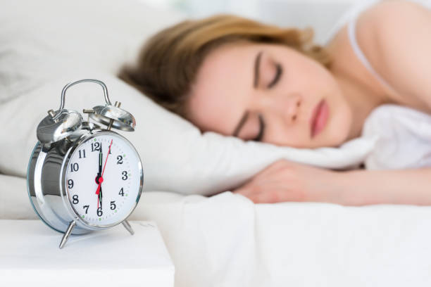 istock selective focus of girl sleeping on bed with alarm clock 971101658