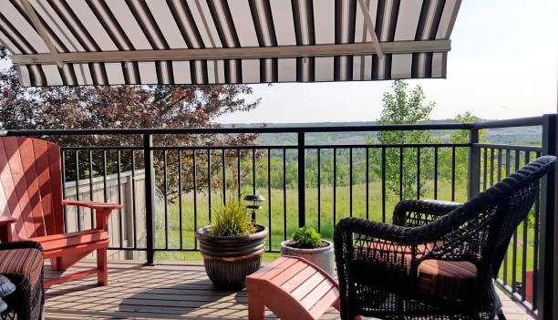 Summer Deck Comfort Under The Awning Comfortable deck seating arrangement under the awning.  Adirondack chair,Wicker chair,potted plants. awning stock pictures, royalty-free photos & images