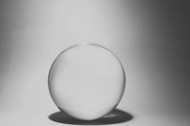 Red glass ball with bubbles inside lit by light with a white background