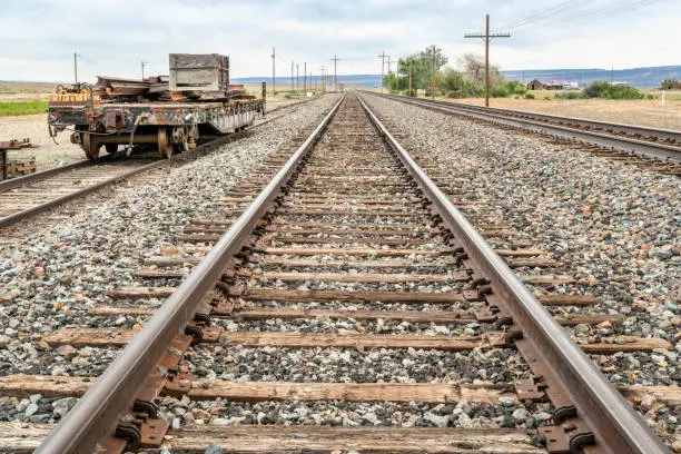 railroad tracks in desert backcountry of Utah with a repir car