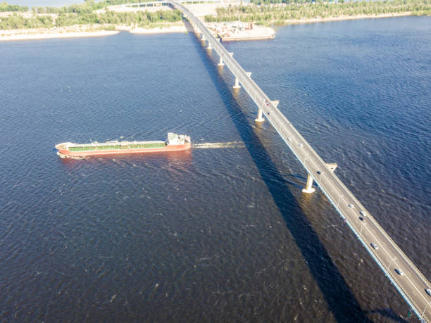 navio de carga grande passa debaixo da ponte sobre o rio - barge canal construction engineering - fotografias e filmes do acervo