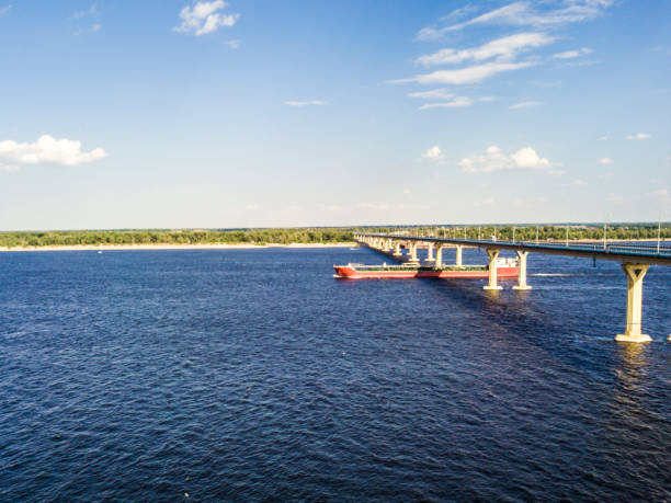 cargo ship barge en passant sous le pont franchissant la rivière - europe bridge editorial eastern europe photos et images de collection