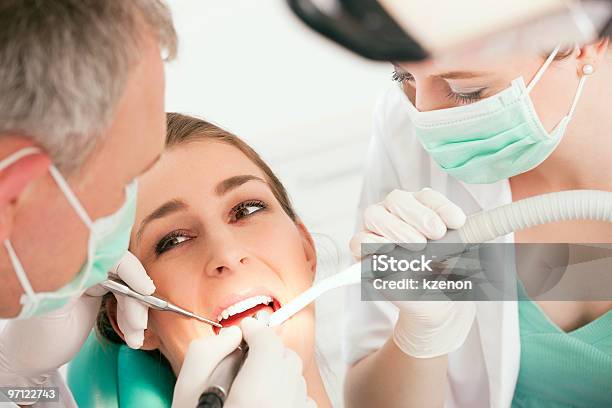 A Dentist With His Patient Giving A Dental Treatment Stock Photo - Download Image Now