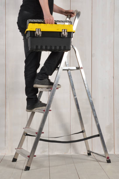 istock Feet of a carpenter ready for work on a ladder with tool box 971230286