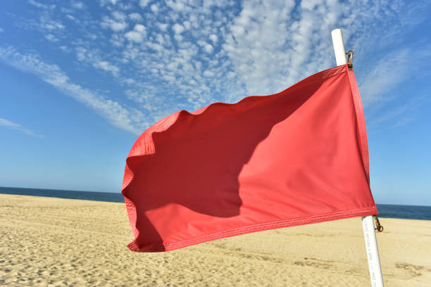 istock red flag flying in wind on flag pole 971243694