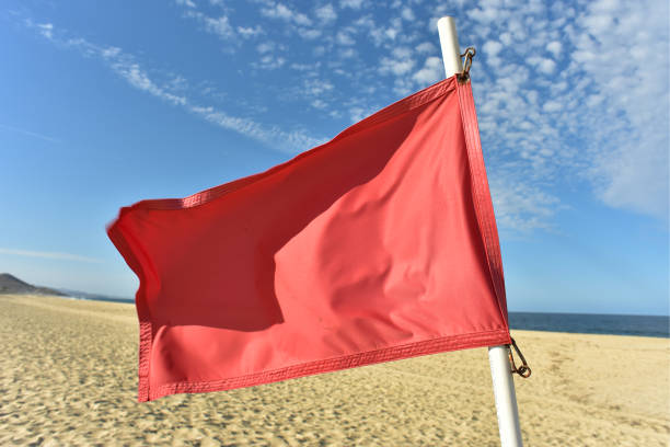 istock red flag flying in wind on flag pole 971243740