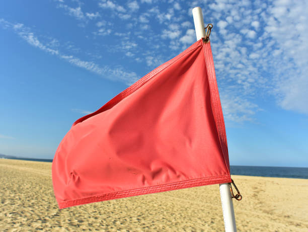 istock red flag flying in wind on flag pole 971243840