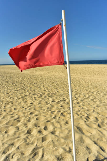 istock red flag flying in wind on flag pole 971243928