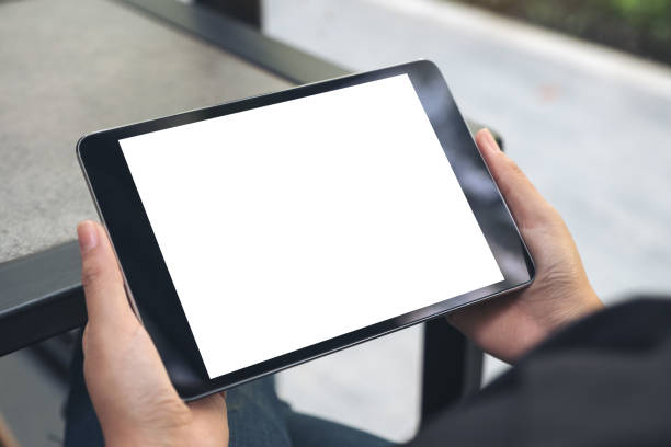 istock Mockup image of hands holding black tablet pc with blank white desktop screen 971252894