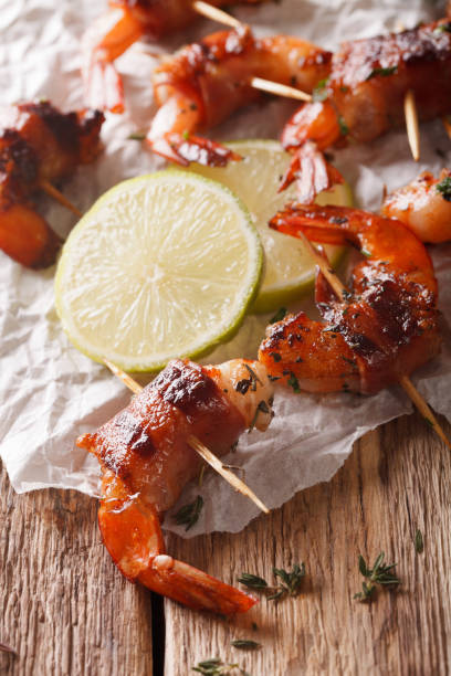 istock Grilled shrimp with bacon, thyme and lime close up. vertical 971270916