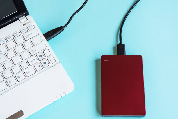 istock Modern laptop keyboard and storage, external hard drive for many data information on pastel color table. 971273290