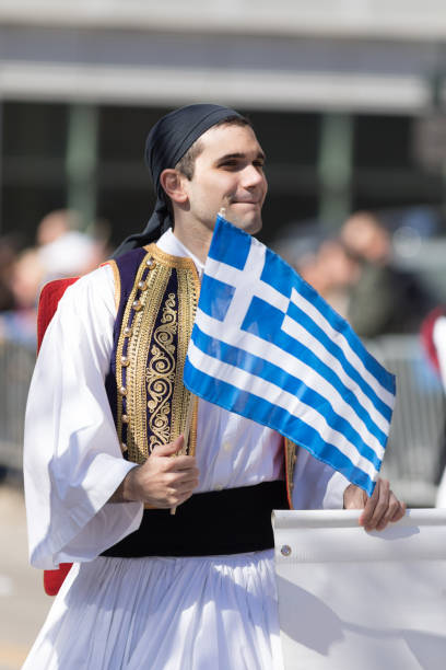 Chicago, Illinois, USA - April 29, 2018 Greek man wearing traditional clothing waving the greek flag at the  Greek Independence  Day Parade