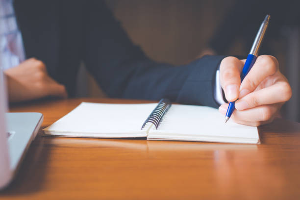 istock Business woman hand  writing on notepad with a pen in office. 971275932