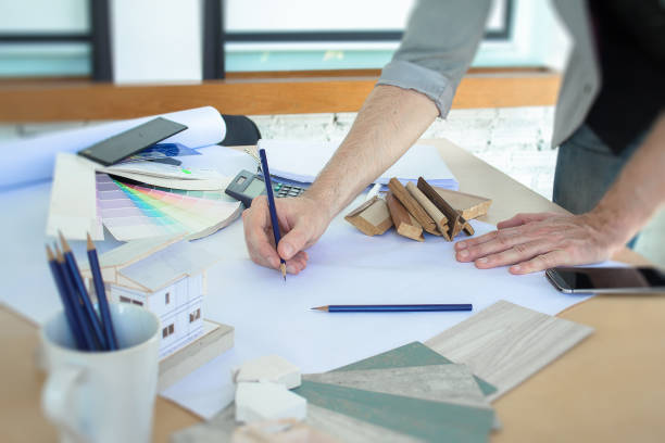 istock Young architects at drawing room table with new construction design. 971278356