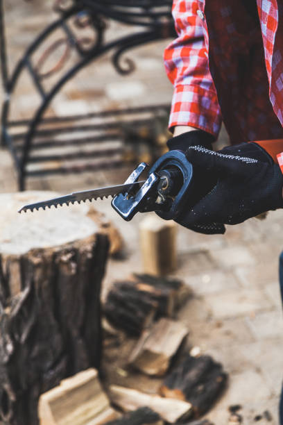 Hands in gloves hold power saw