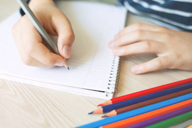 istock Kid holding pencil and writing. 971281098