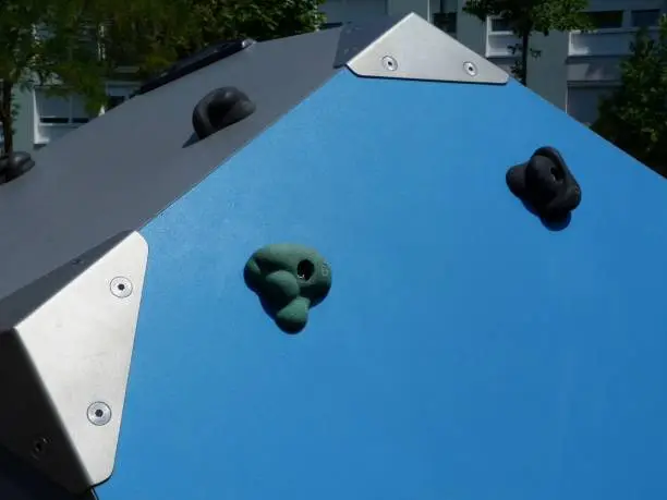 climbing equipment with colorful plastic holds on wooden boxes in playground in public park