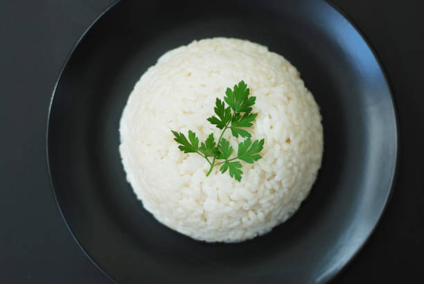 istock Hot Cooked Boiled White Ricen Black Background, Isolated. 971311452