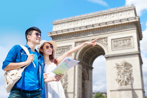 couple travel to paris and take map with arc de triomphe