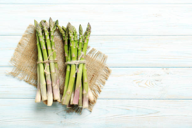 istock Fresh green asparagus on a blue wooden table 971332586
