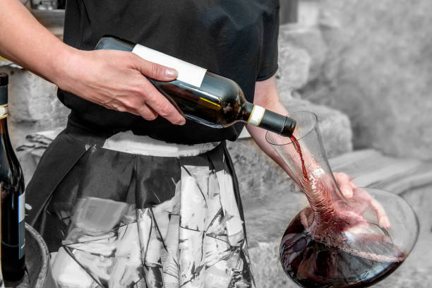 소믈리에 그릇에서 유리에 와인을 부 어 넣는다. 레드 와인의 통 기 통풍입니다. 디 켄 터 - wine decanter elegance pouring 뉴스 사진 이미지