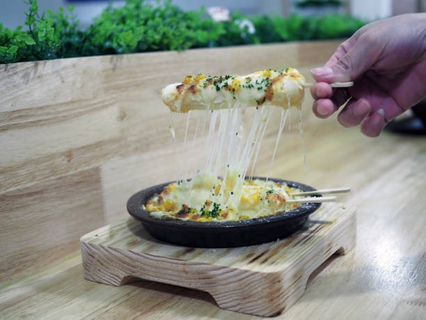 Ddeokbokki or Tokpokki with cheese on metal hot pan.