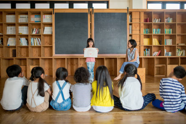 Young school girl giving a presentation in class Young school girl giving a presentation in class. Okayama, Japan japanese boy and girl stock pictures, royalty-free photos & images