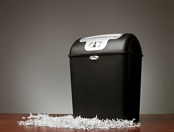 Shredded paper on the ground in front of a shredder stock photo