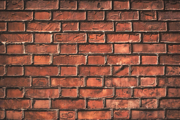 istock Texture of aged red brick wall with cracked weathered structure close-up for designer background 971363208
