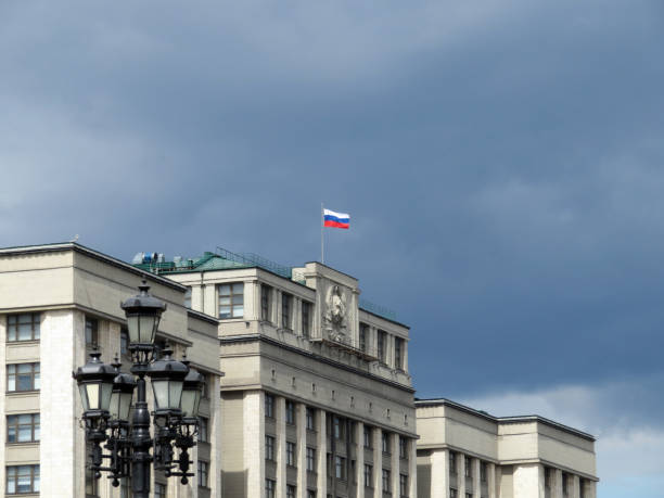 bandera rusa en el edificio del parlamento en moscú contra el oscuro cielo nublado - hoz y martillo fotografías e imágenes de stock