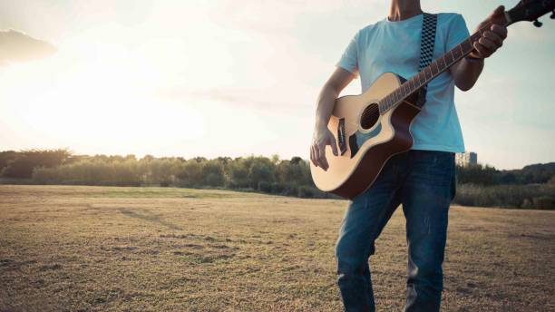istock young man playing acoustic guitar on lawn 971366482