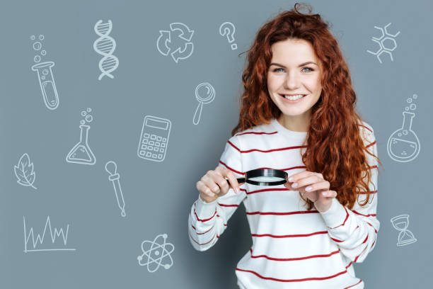istock Clever student feeling excited while standing with a magnifying glass 971370246
