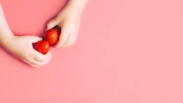 istock Child's hands holding strawberries 971376724