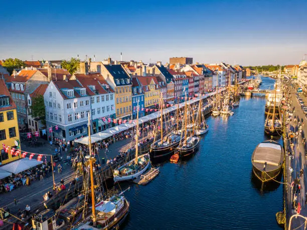 Amazing historical city center. Nyhavn New Harbour canal and entertainment district in Copenhagen, Denmark. The canal harbours many historical wooden ships. Aerial view from the top.