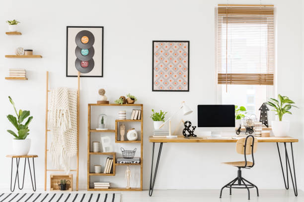 photo réelle d’un intérieur au travail avec un ordinateur sur un bureau à côté d’une chaise et une étagère avec des ornements, des affiches sur un mur et une fenêtre avec stores - isolated remote plaid nobody photos et images de collection