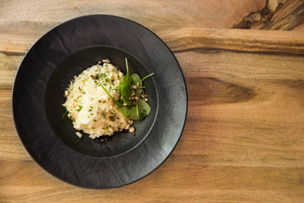 istock Above view at risotto with gem fit and levisticum celery on a wood table composition 971389088