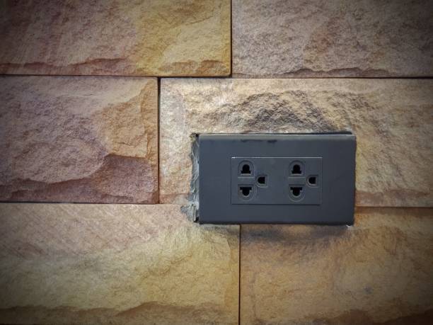 istock double power electric plug outlet on sandstone wall texture 971391148