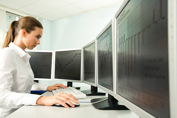 istock Woman working in front of five computer screens 97139295