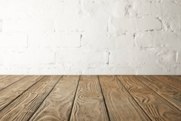istock brown wooden tabletop and white wall with bricks 971395740