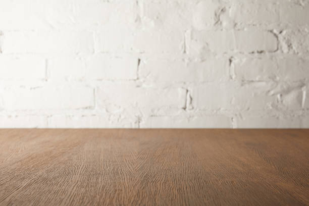 istock brown wooden tabletop and white wall with bricks 971396430