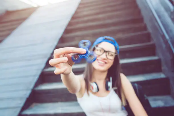 Photo of Girl playing with fidget spinner