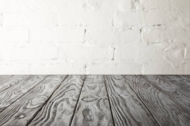 istock grey wooden surface and white wall with bricks 971399980