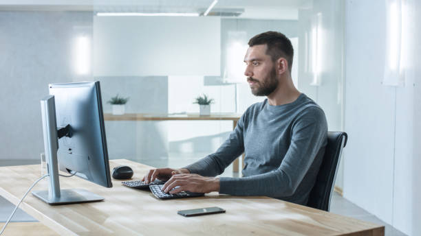 istock Creative Man Working on the Computer in the Bright Modern Office. 971401212
