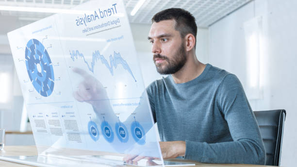 istock In the Near Future Successful Trader Works on Computer with Transparent Display that Shows Interactive Line Charts and Other Useful Information. His Office is Bright and Modern. 971403498