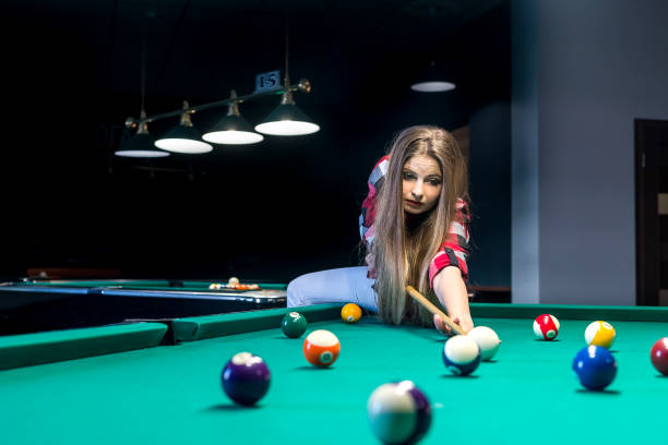 istock Woman going hit a ball with cue in billiard 971410262