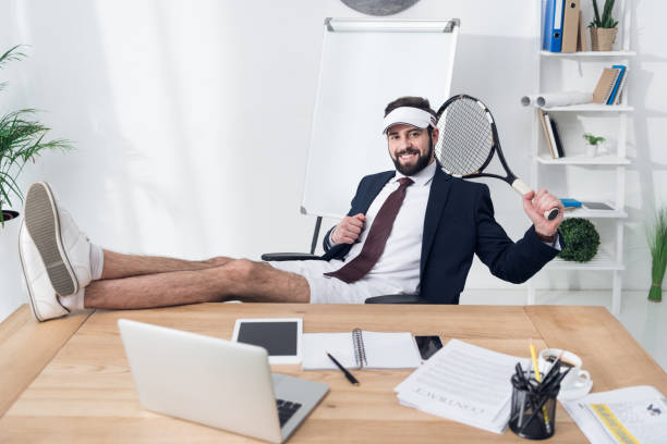 Young Businessman In Cap With Tennis Racket Resting At Workplace In Office  Stock Photo - Download Image Now - iStock
