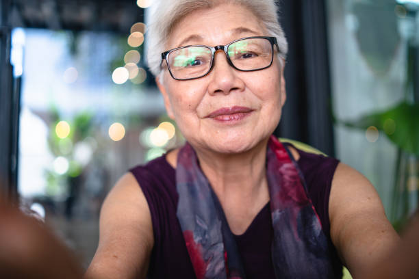 señora mayor asiático tomando su selfie. - portrait human face chinese ethnicity real people fotografías e imágenes de stock