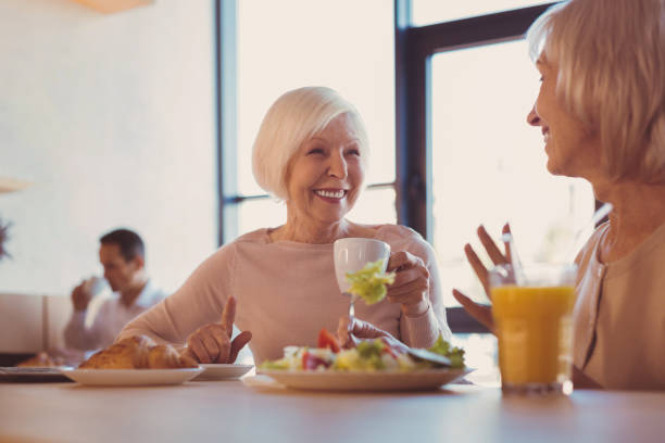 istock Two upbeat elderly women talking in cafe 971427454