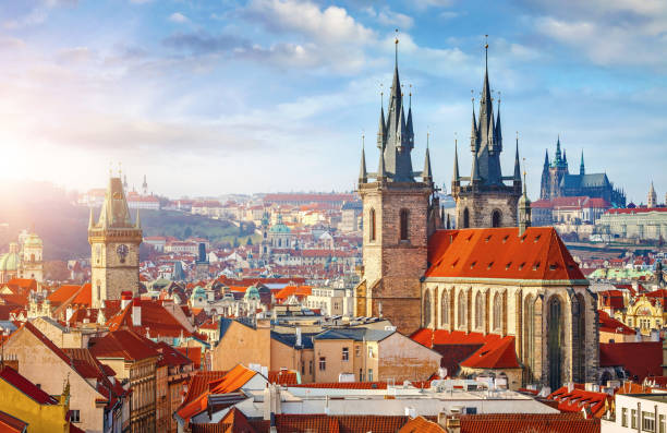 High spires towers of Tyn church in Prague city High spires towers of Tyn church in Prague city (Church of Our Lady before Tyn cathedral) urban landscape panorama with red roofs of houses in old town and blue sky with clouds. bohemia czech republic photos stock pictures, royalty-free photos & images